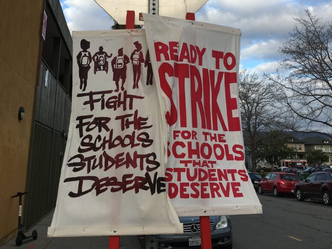Two white cloth signs with red text. The sign on the left reads, "Fight for the schools students deserve," and the sign on the right says "Ready to strike for the schools that students deserve." Signs were used during the 2019 OEA strike.